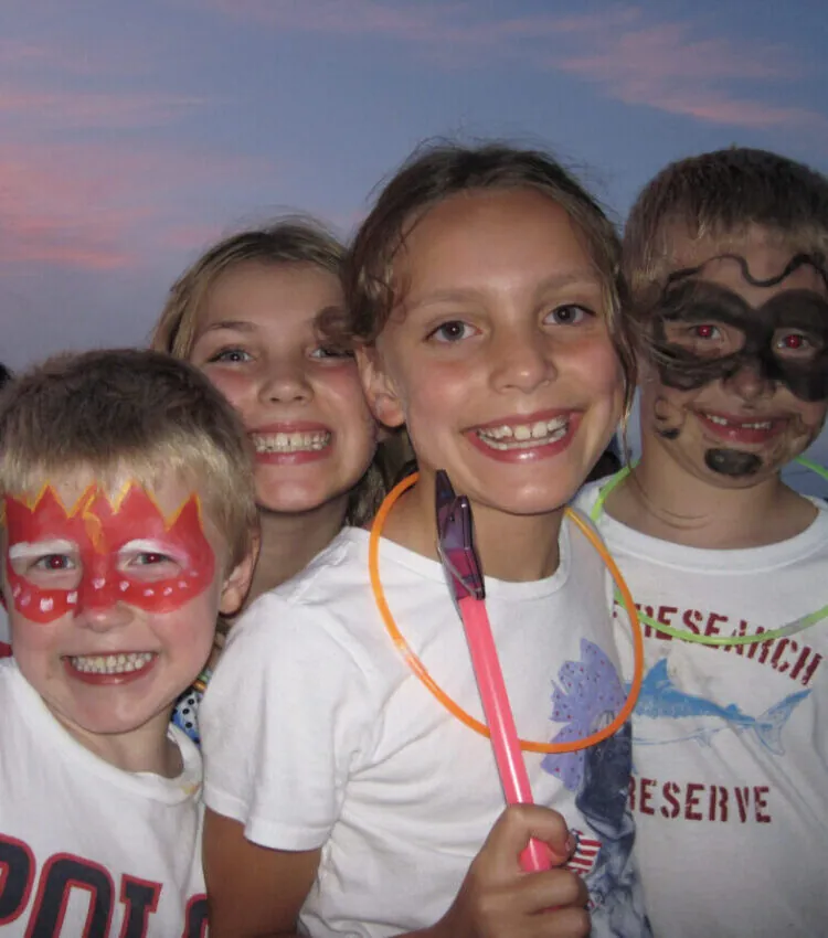 smiling kids with facepaint and glowsticks